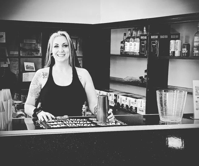 Mandi, the Partytender, smiling behind the bar